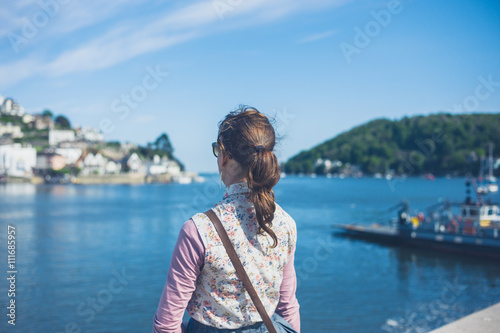 Young woman standing by water in small village