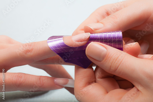 Manicure. Master make nail extension. Finger closeup
