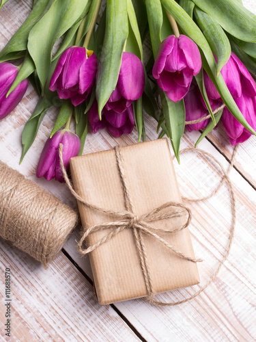 Fototapeta Naklejka Na Ścianę i Meble -  Gift box and tulips bouquet on white wooden background - retro style