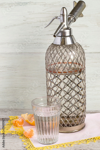 Wallpaper Mural  Sparkling water.
   The siphon and a glass of sparkling water on a napkin on a light wooden background. Torontodigital.ca