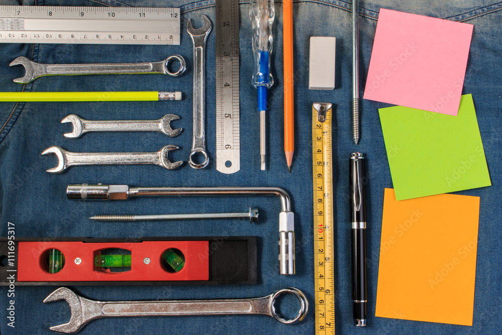 Wrench tools on a denim workers with blank note paper for text. Flat lay style.