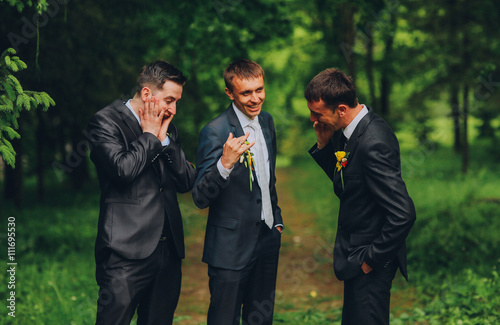 Groom showing wedding ring on his hand, his cronies. Friends emotions. Laughter. joke