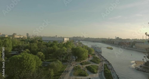 Aerial view of Peter the Great Statue on a summer spring day at sunset. Crowds of people walking along the park near river.  
