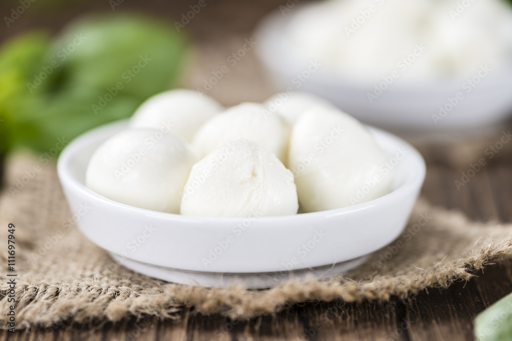 Small Mozzarella balls (on wooden background)