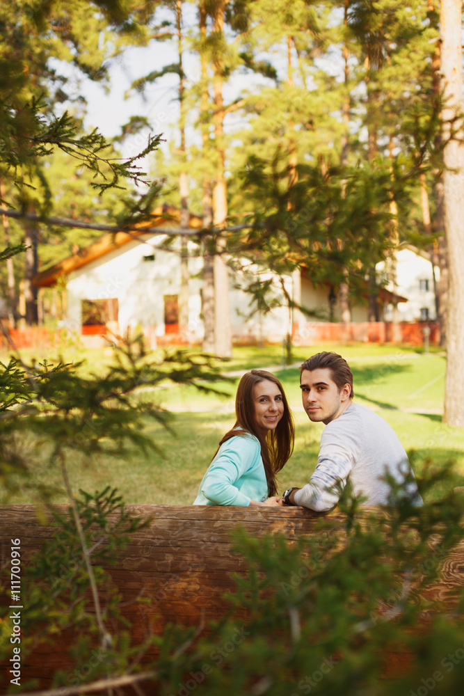 Naklejka premium Young couple in love walking in the autumn park holding hands looking in the sunset