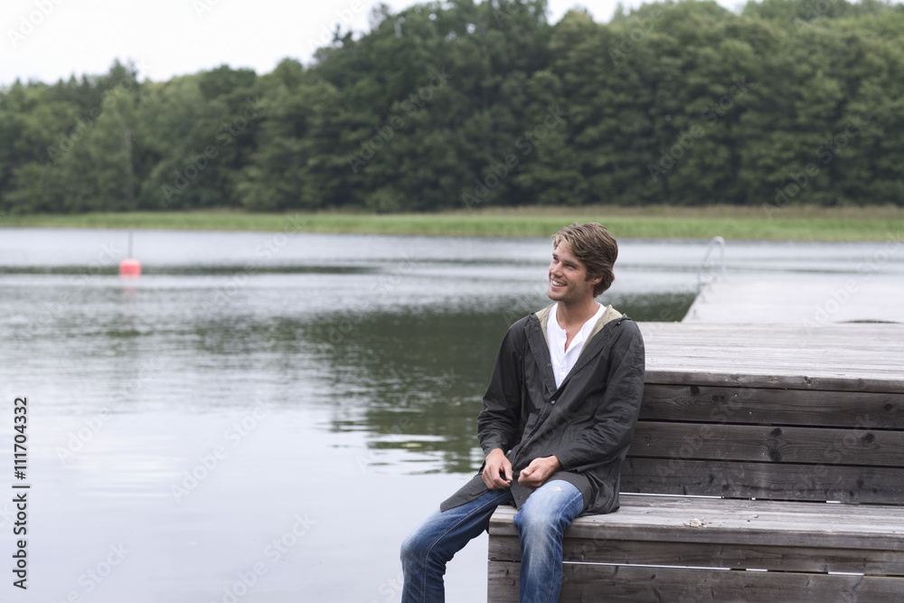 A man sitting on a jetty, Sweden. A man sitting on a jetty, Sweden.