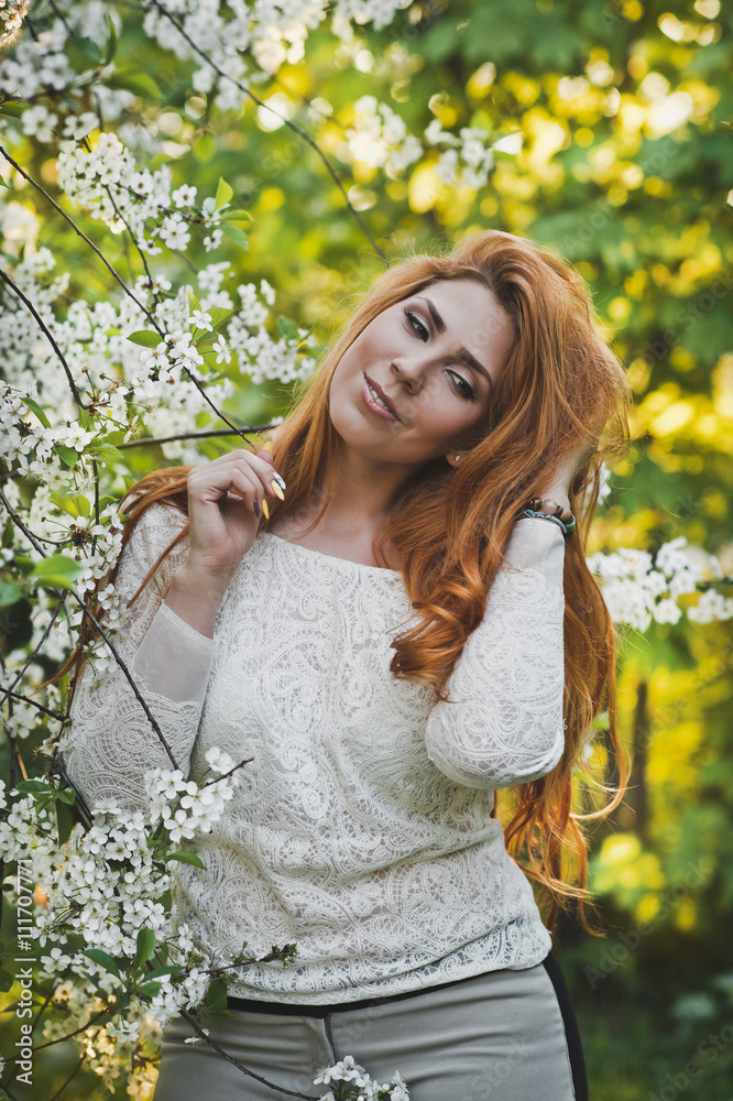 Portrait of a girl with red hair among the flowers of cherry and Portrait of a girl with red hair among the flowers of cherry and