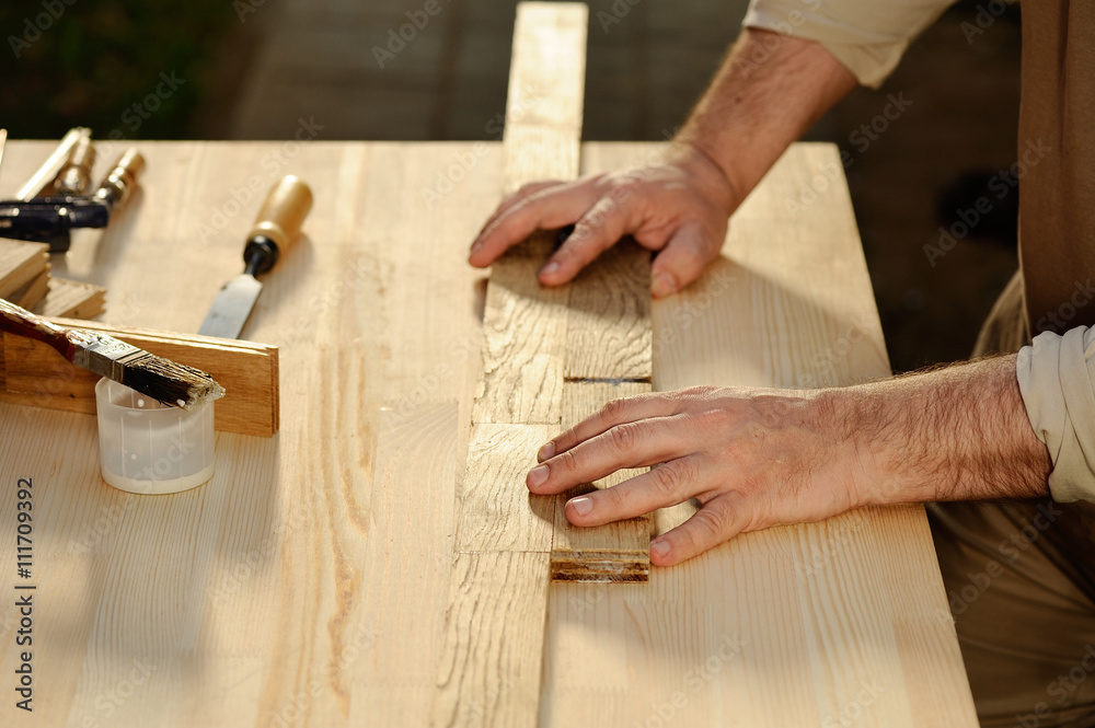 Carpenter at work arranging pieces of wood on table Carpenter at work arranging pieces of wood on table