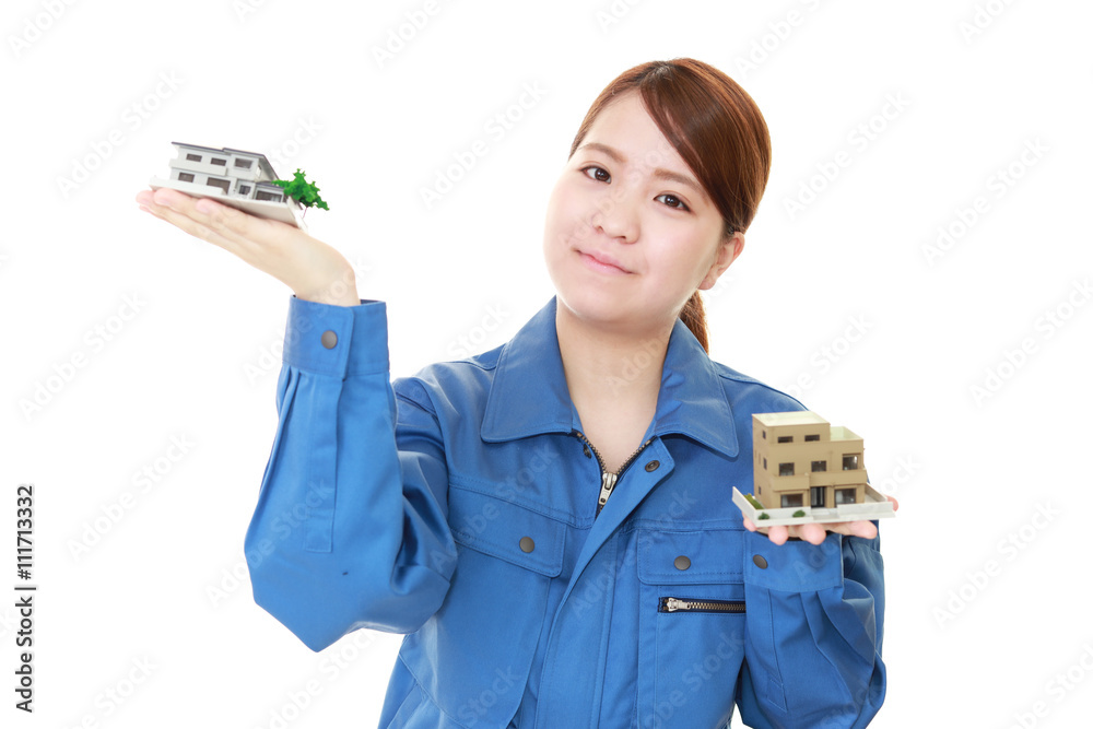 住宅模型を持つ笑顔の女性労働者
