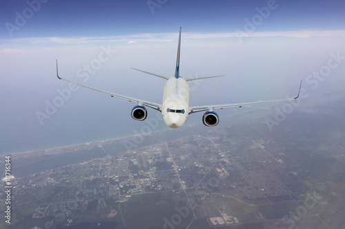 Fototapeta Naklejka Na Ścianę i Meble -  Passenger jet flying at a high altitude over land