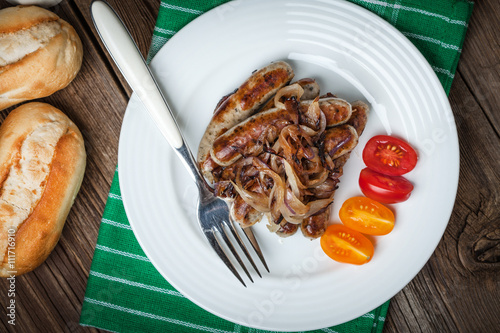 Fried Fried white sausages with onion on the plate.white sausage photo