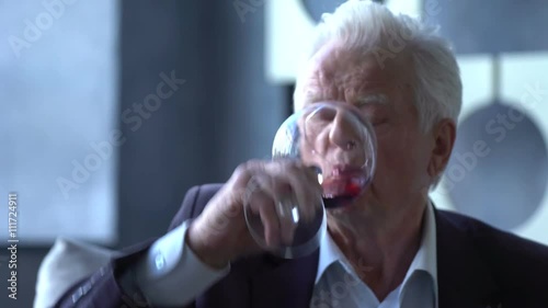 elderly man drinking wine at home