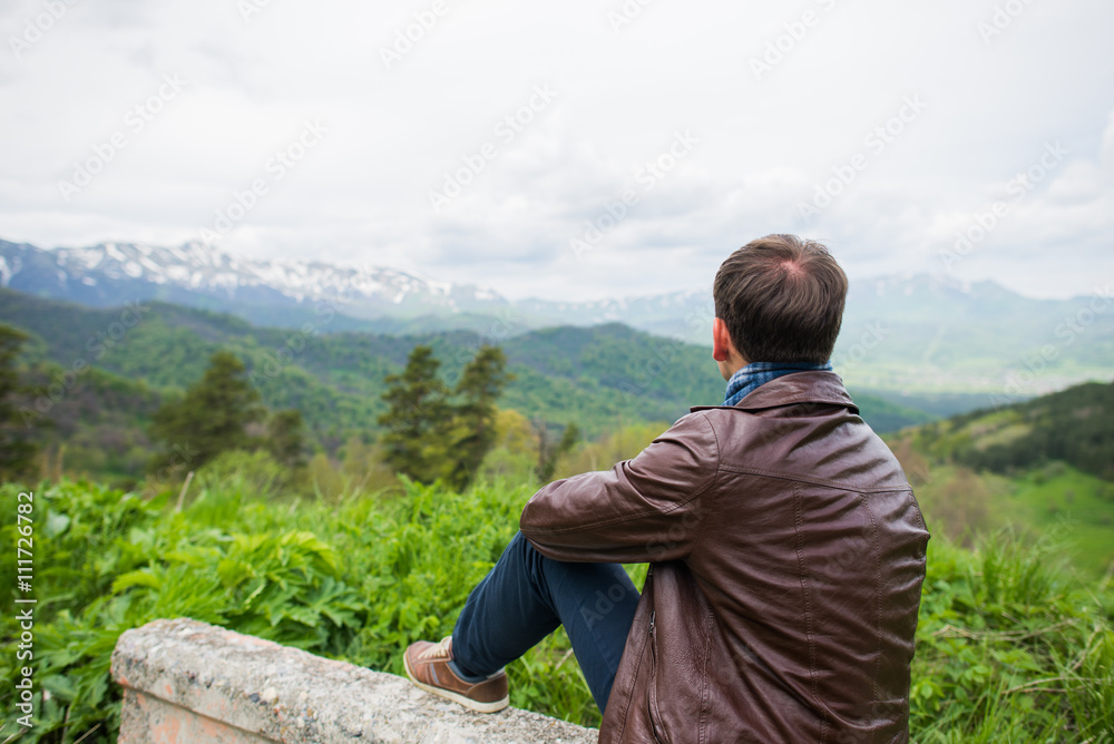 Young man looking beautiful view at the mountains