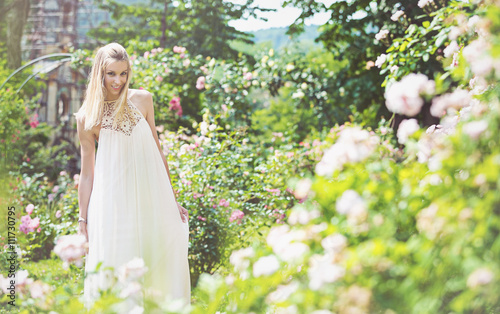 Portrait of beautiful natural young woman in the rose garden