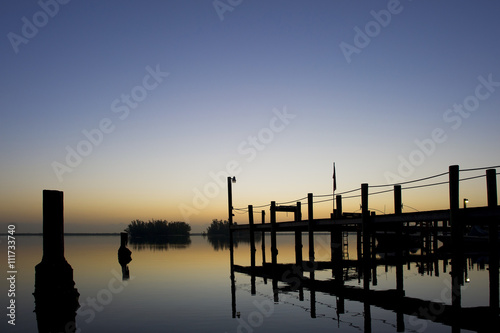 A large dock at dusk after a calm sunset.