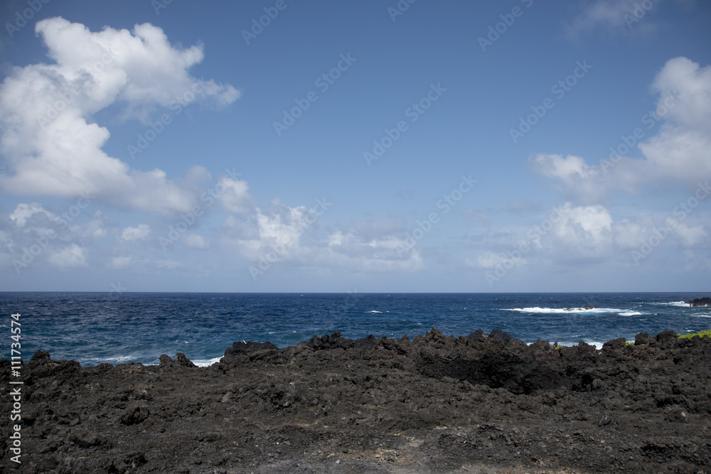 A rocky volcanic shoreline with turquoise ocean waves. A rocky volcanic shoreline with turquoise ocean waves.