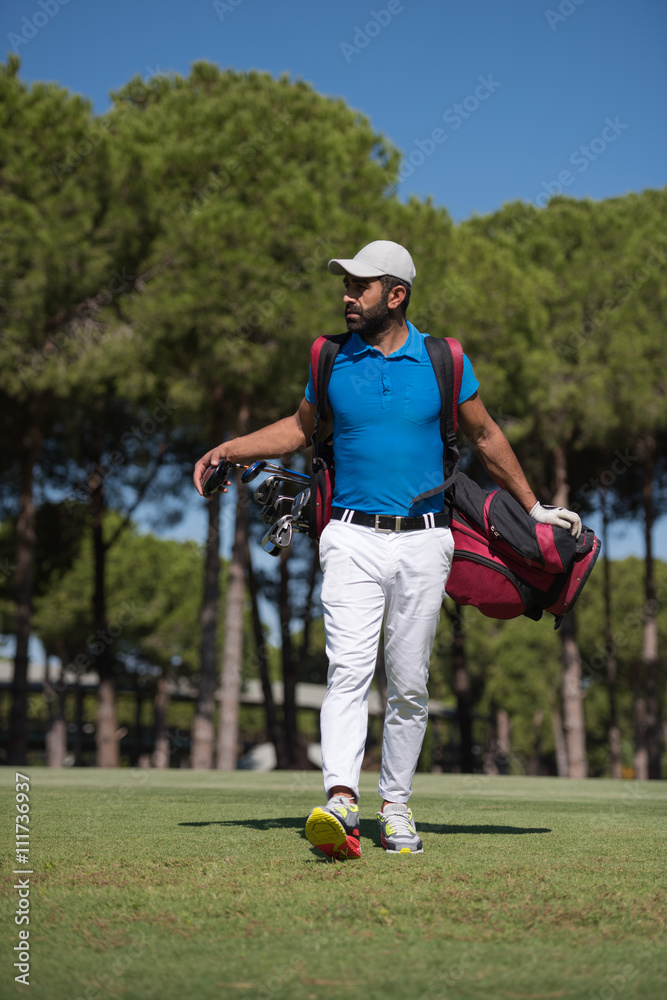 Obraz premium golf player walking and carrying bag
