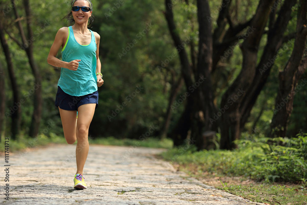 young fitness woman trail runner running in forest young fitness woman trail runner running in forest