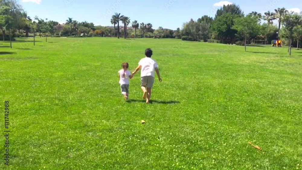 Brother and sister playing together at the park in a summer sunny day. Brother and sister concept. Brother and sister playing together at the park in a summer sunny day. Brother and sister concept.
