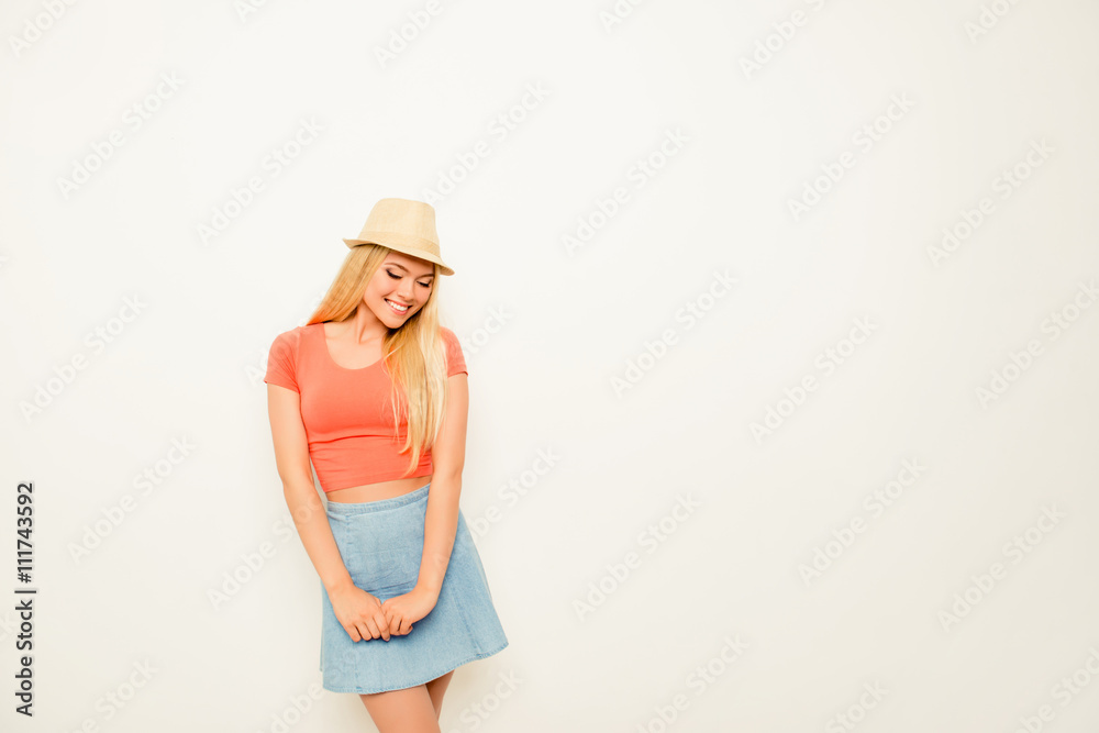 Shy smiling young girl posing in skirt and hat