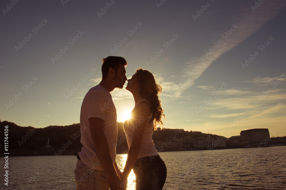 Silhouette of couple in love kissing and watching  on the sunset
