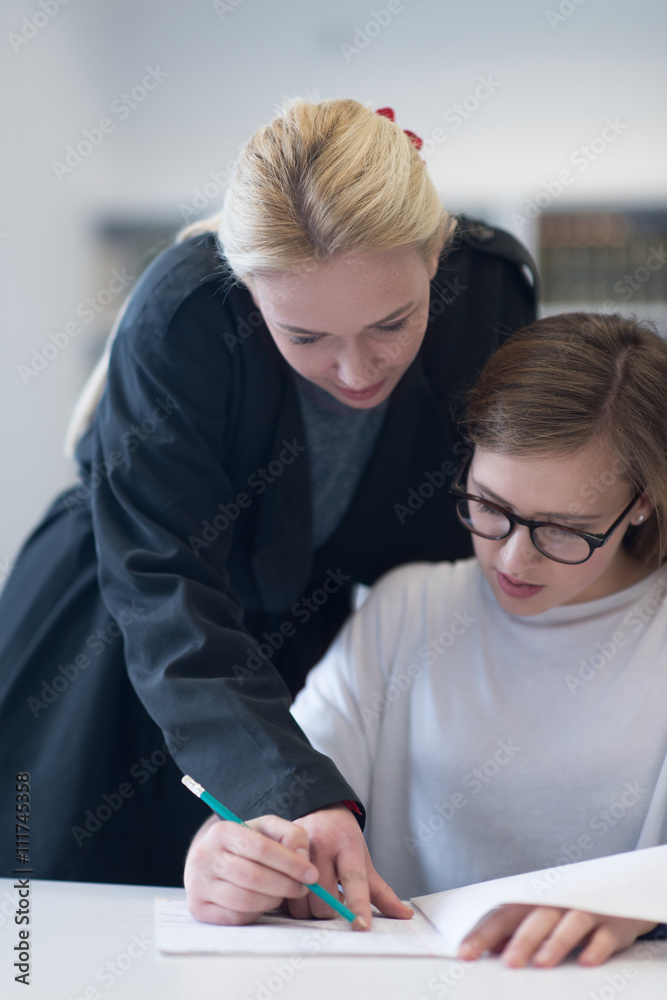 female teacher helping students on class