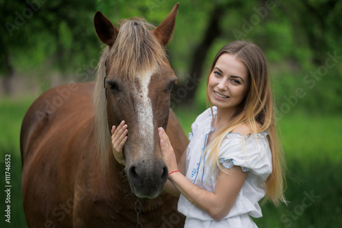 outdoor portrait of young beautiful woman with horse © makam1969