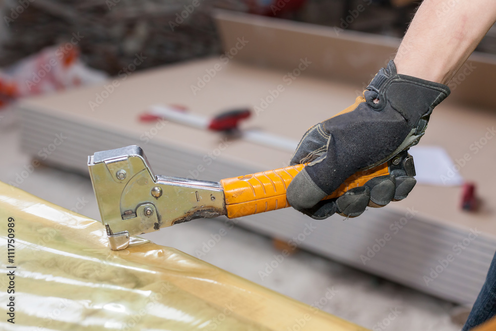 Building A Wall For Frame House Worker Installing Vapor Barrier Film