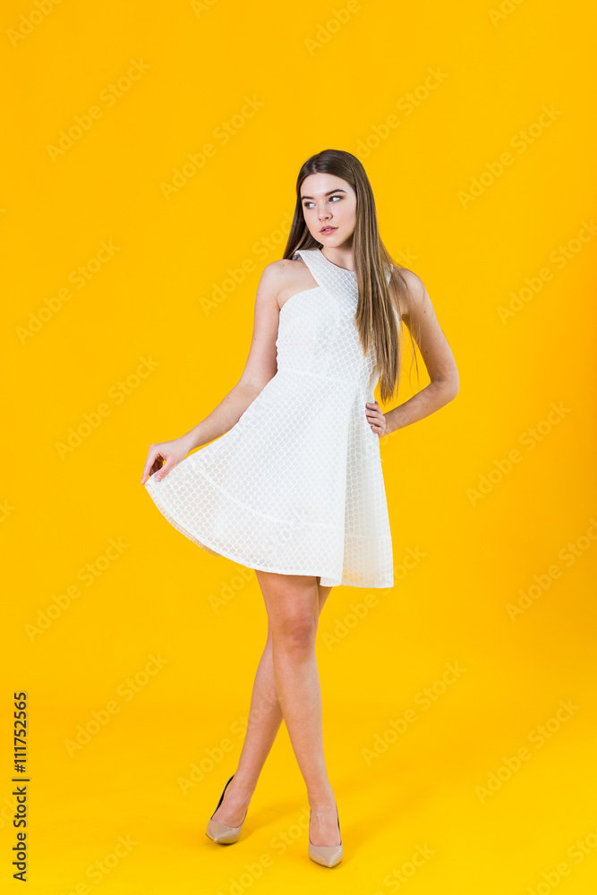 beautiful young blonde woman in nice spring dress, posing on yellow background in studio beautiful young blonde woman in nice spring dress, posing on yellow background in studio