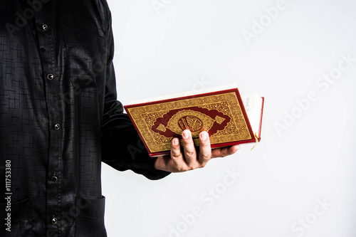 Koran in hand ,Quran in hand - holy book of Muslims , on white background photo