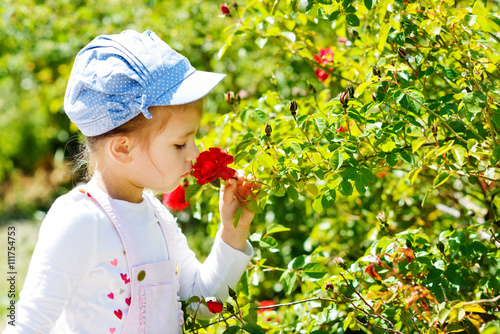 little girl  smelling rose