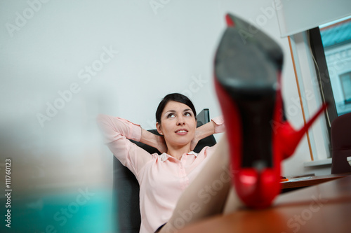 Relaxed businesswoman with legs on the desk