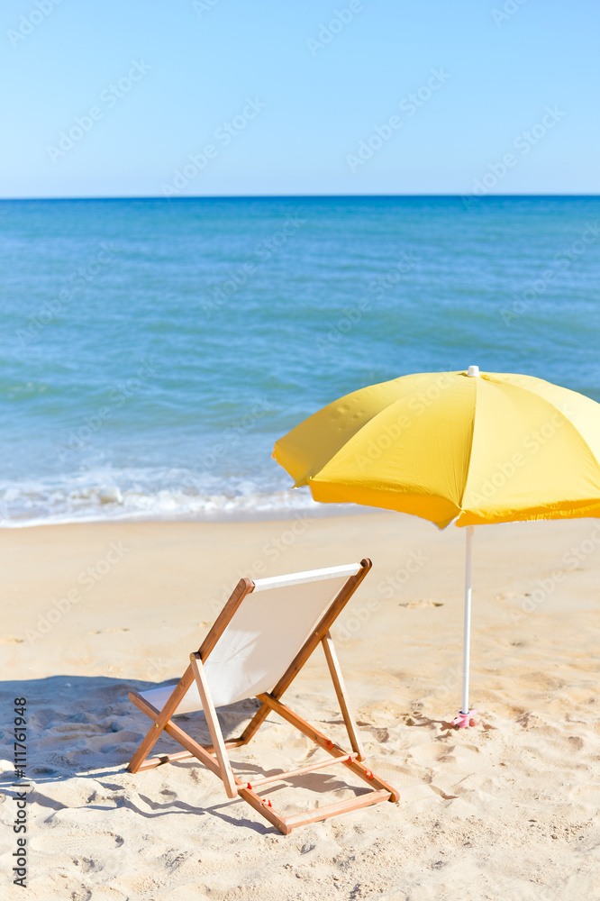 Back View Of Deckchair, Sun Lounger Under Umbrella On Sand Beach. 