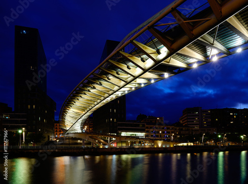 Bilbao, Baskenland in Spanien - Brücke Zubizuri über den Ria del Nervion zur blauen Stunde abends mit Lichtspiegelungen im Wasser © Michael Gellner