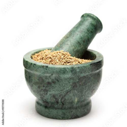 Organic Carom or Ajwain (Trachyspermum ammi) on marble pestle Isolated on white background. photo