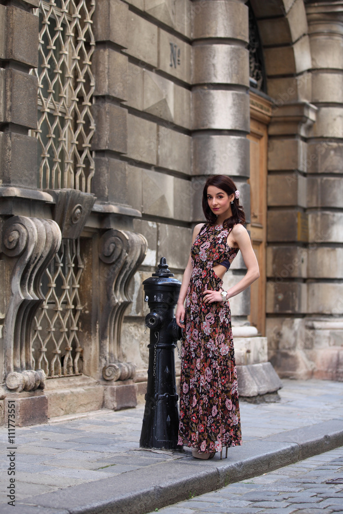 Elegant young woman with summer dress standing on the street