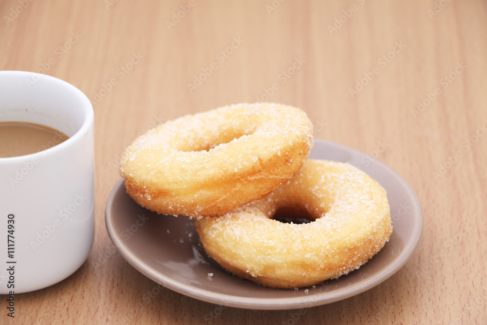 yeast donut with sugar and coffee on wooden background yeast donut with sugar and coffee on wooden background