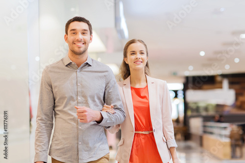 happy young couple with shopping bags in mall