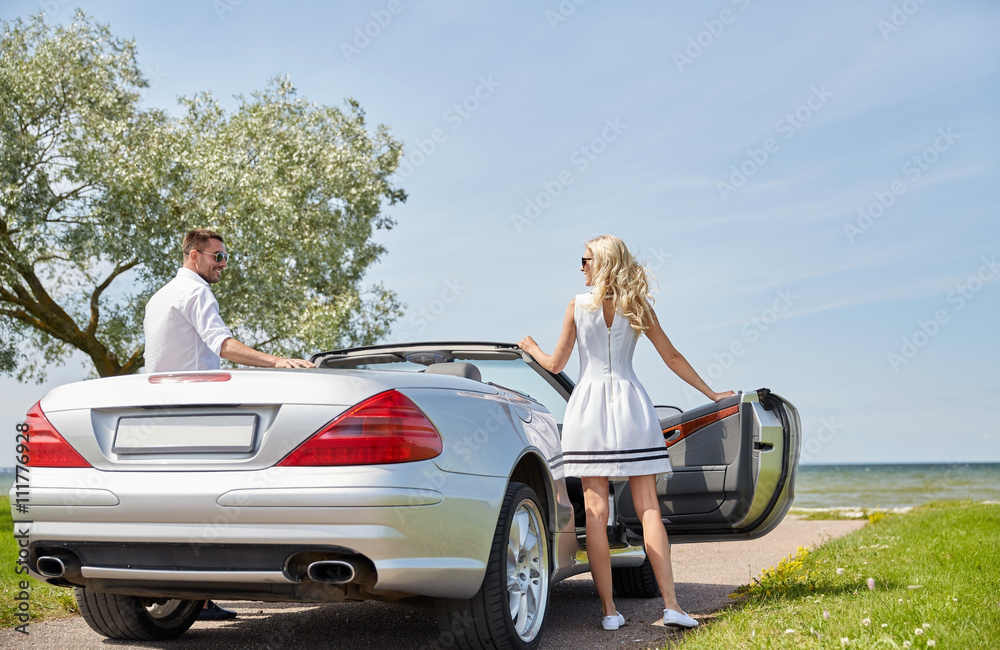 happy man and woman near cabriolet car at sea happy man and woman near cabriolet car at sea