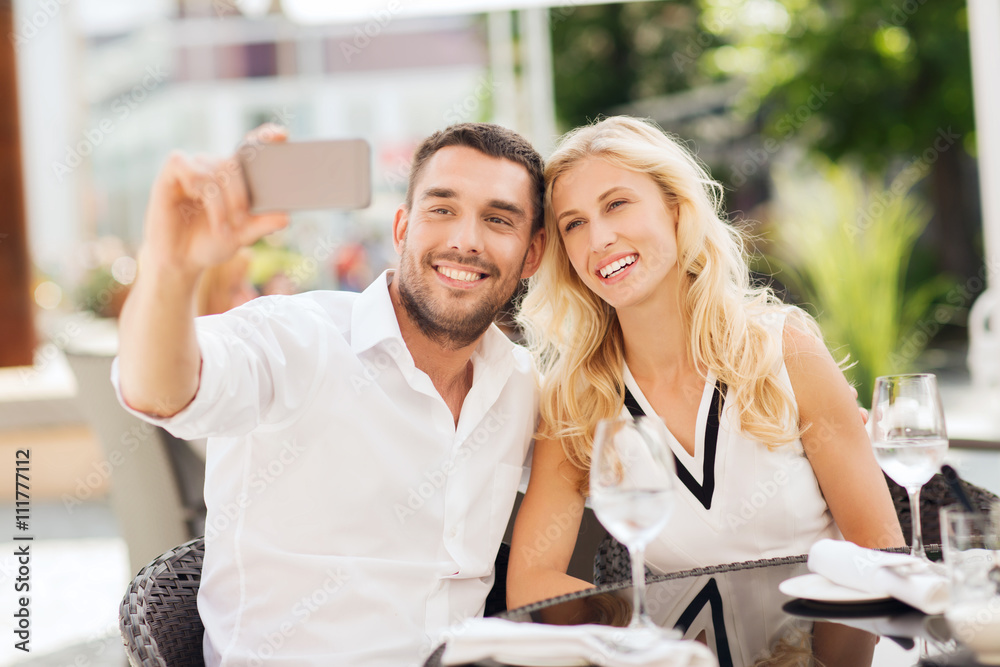 happy couple taking selfie with smatphone at cafe happy couple taking selfie with smatphone at cafe