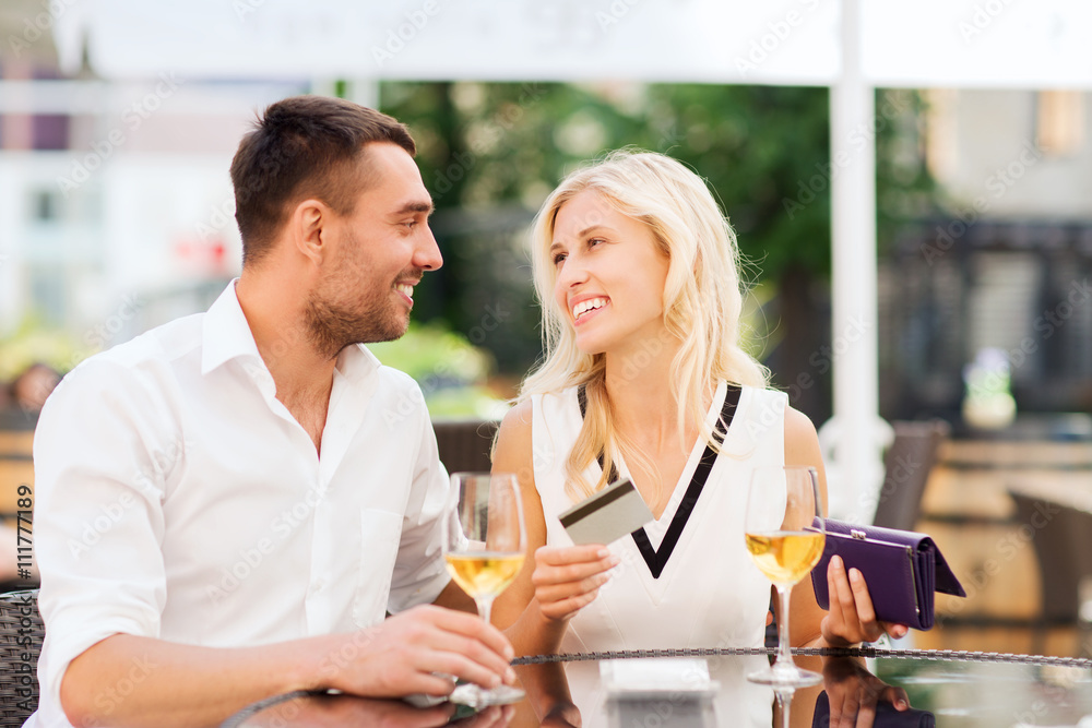 happy couple with bank card and bill at restaurant happy couple with bank card and bill at restaurant