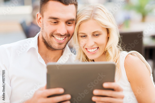 happy couple with tablet pc at restaurant lounge