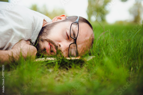 weary man relaxing outdoors lying on the grass