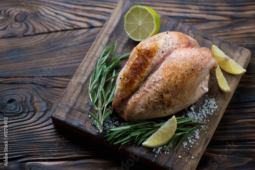 Whole roasted chicken breast in a rustic wooden setting