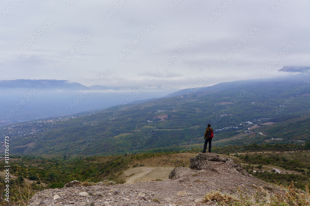 Man hiking with backpack in the green mountains in summer Man hiking with backpack in the green mountains in summer