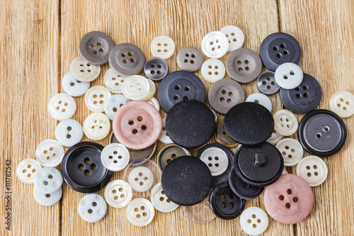 Various sewing buttons on a wooden table 