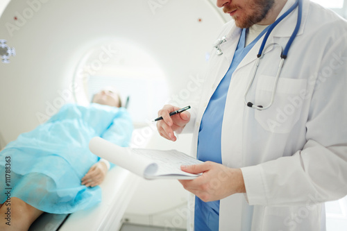 Принти на полотні Doctor at CT scan machine