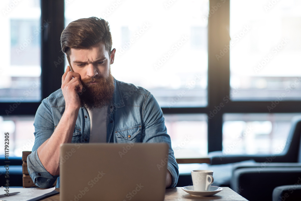 Pleasant bearded man sitting at the table Pleasant bearded man sitting at the table