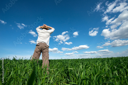 young man on green field of wheat
