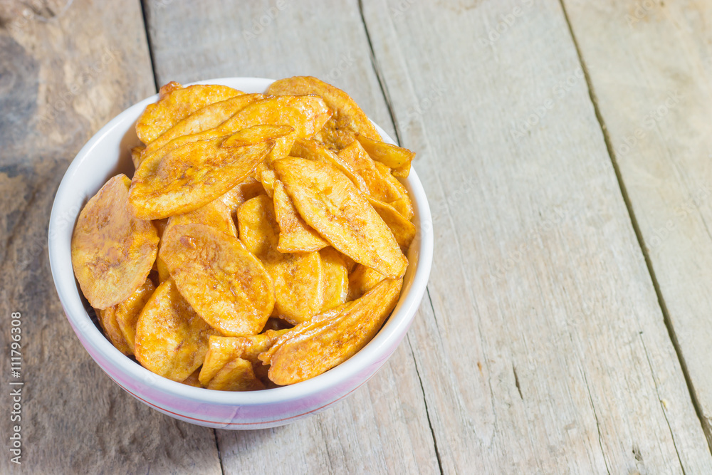 Homemade Banana Chips Baked with honey on wood table Homemade Banana Chips Baked with honey on wood table